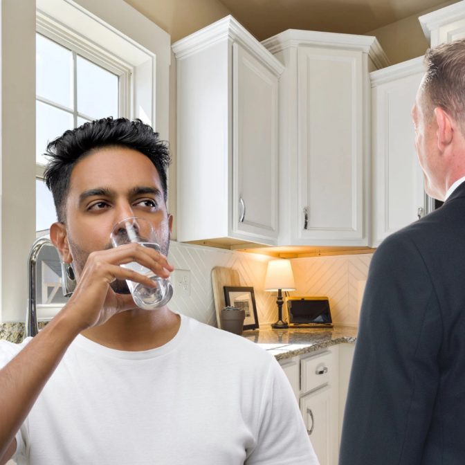 Cliente probando un vaso de agua ionizada en su cocina durante la demostración